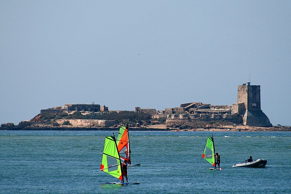 Castillo de Sancti Petri en su islote, con windsurfistas en el caño